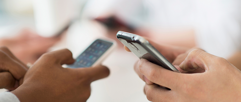 Hands typing on mobile phones