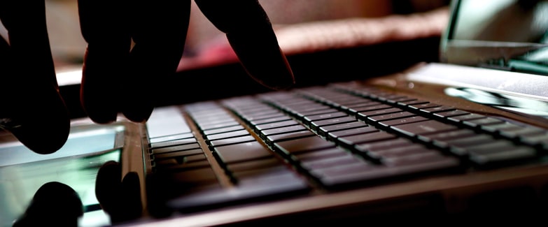 Image of Hand Typing on Laptop Keyboard