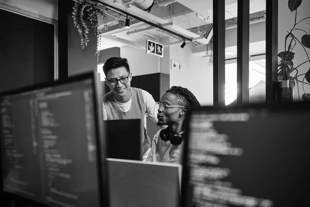Two security professionals reviewing computer screens for cloud DLP monitoring