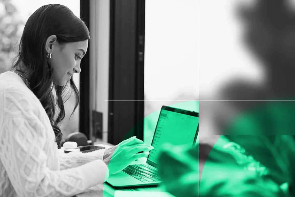 Professional reviewing email on a laptop in a modern workspace.