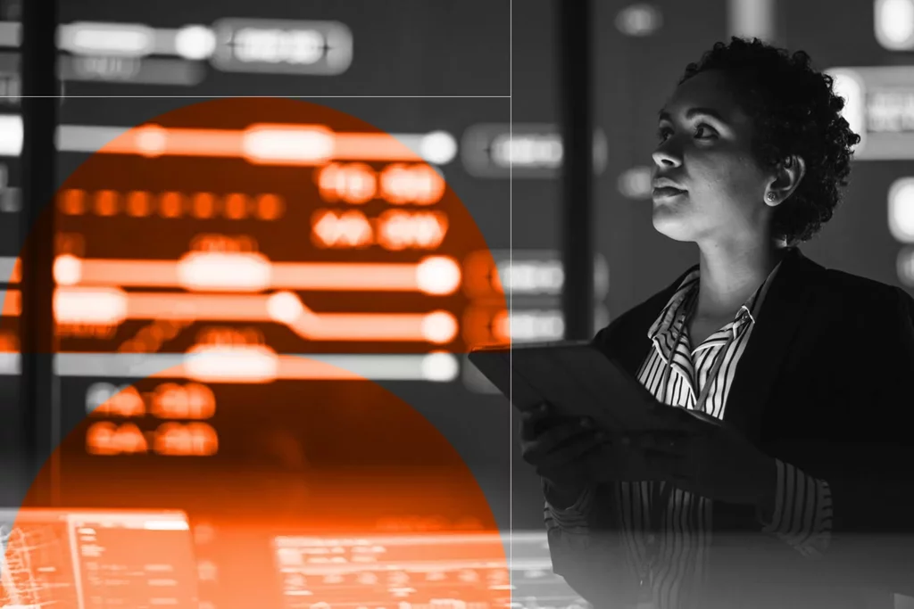 Investigator holding a tablet while reviewing digital information on multiple screens