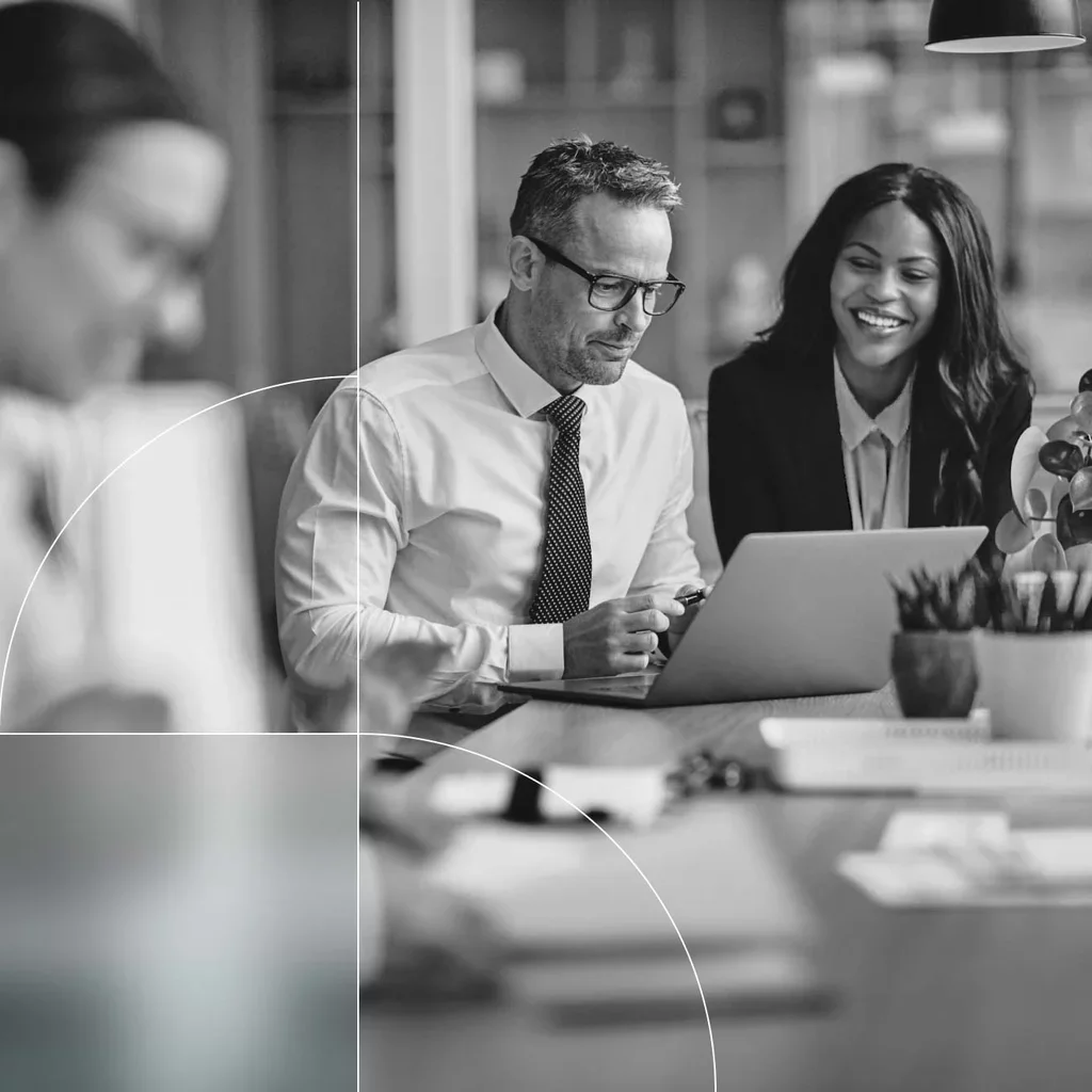 Business professionals reviewing information together on a laptop