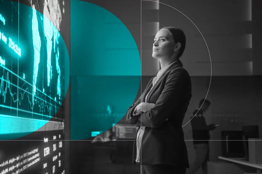 Business professional standing beside a digital data display in a modern office