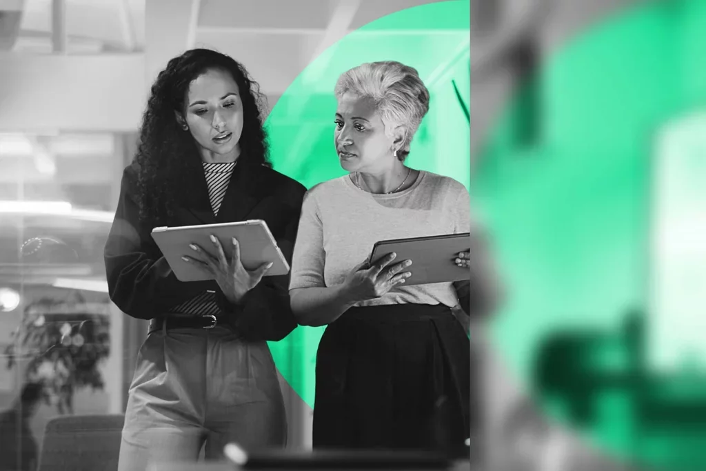Two business professionals reviewing tablets to monitor and stop email threats