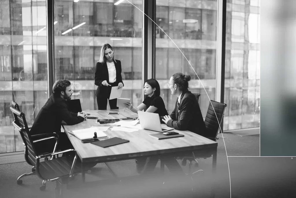 Business team reviewing data and documents during a meeting in a modern conference room.