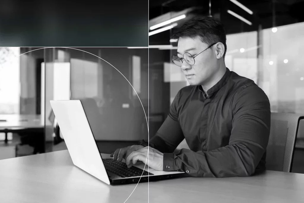 Business professional working on a laptop in a modern office.