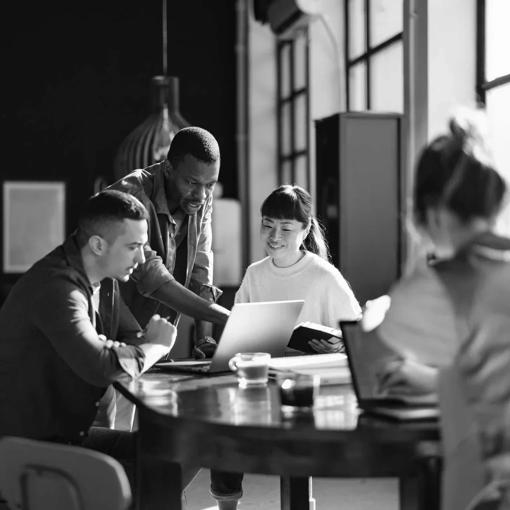 Cybersecurity team collaborating around a laptop in the workplace