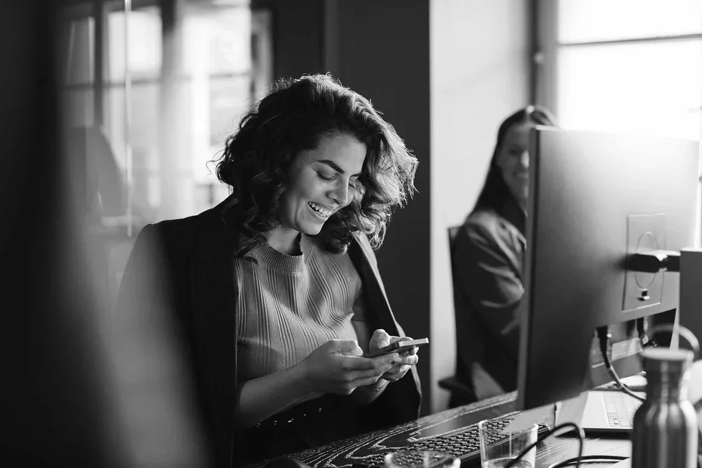 Data protection professional using a mobile device at her workstation