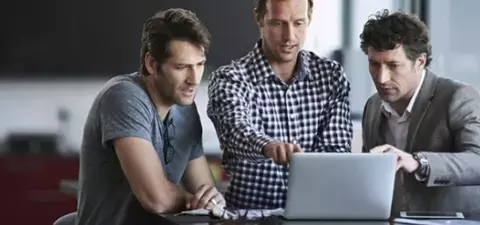 Male Employees Standing In Front of Laptop Protected by Cloud App Security