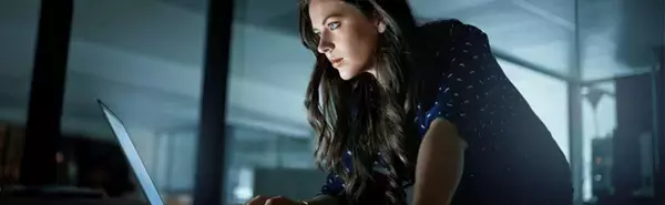 Woman Uses Laptop Protected by Digital Security Risk Solution