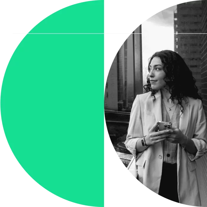 Business professional holding a smartphone by an office window, framed by large green, white, and black circular graphic shapes.