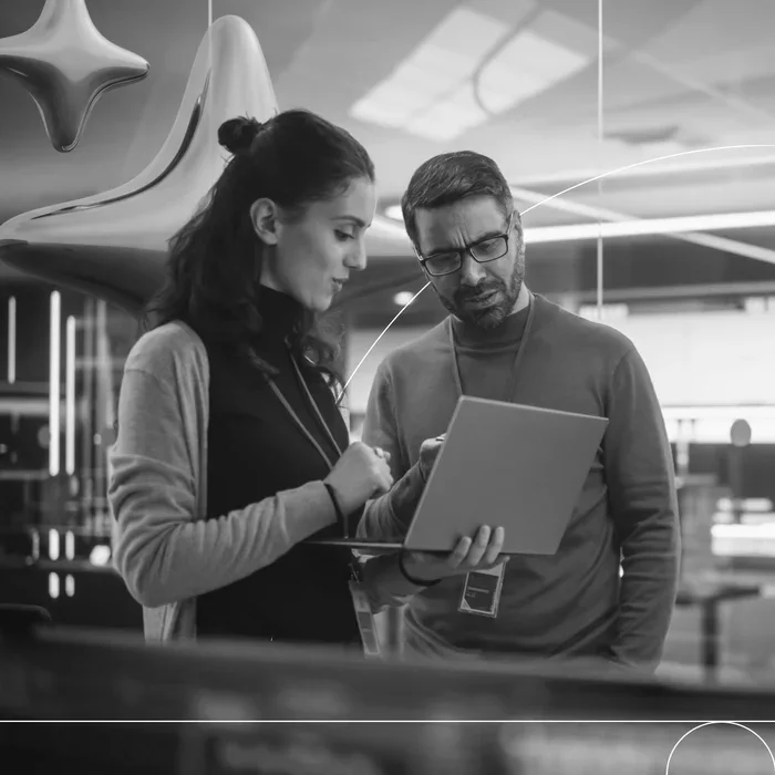 Two business professionals reviewing information on a tablet in a modern office, illustrating collaboration and secure AI access.