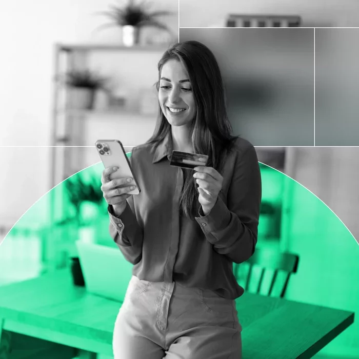 Woman using a smartphone and credit card to complete a digital payment.