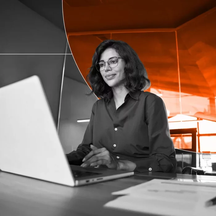 Professional working on a laptop at a desk in a modern office.