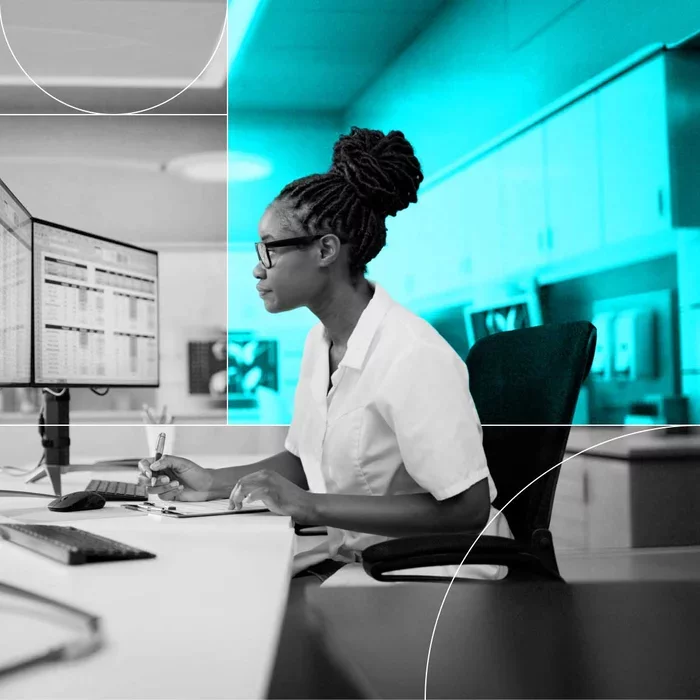 Professional reviews data displayed across computer monitors in a workplace.