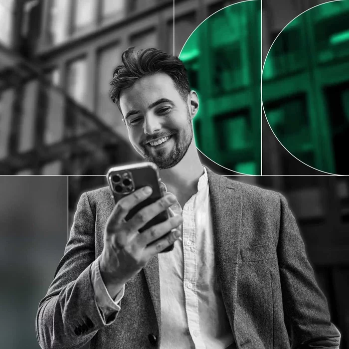 Business professional using a smartphone outside an office building.
