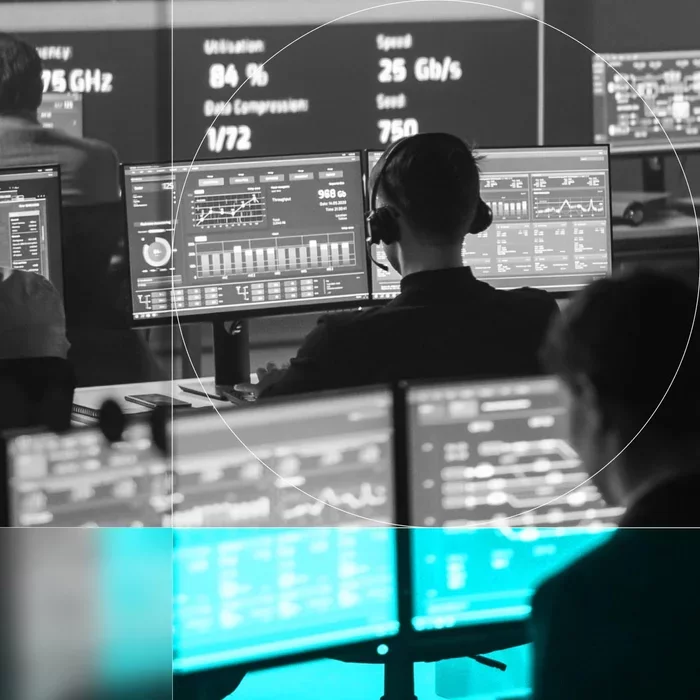 Security operations team monitors data and system activity across multiple screens.