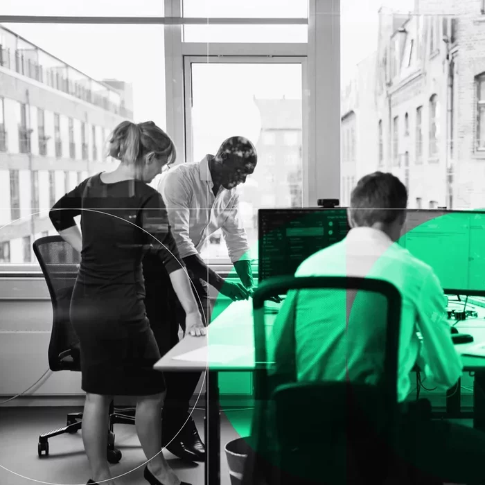 Cybersecurity team reviews computer systems and security data in an office