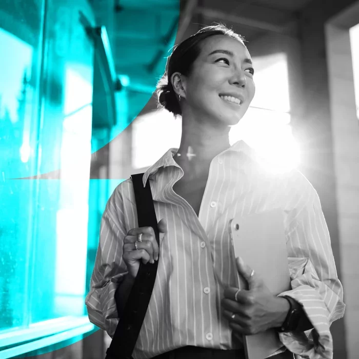Professional carrying a tablet while walking through a modern workplace
