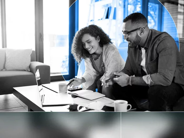 Two professionals collaborating over a laptop and notebook, framed by a blue circular graphic.