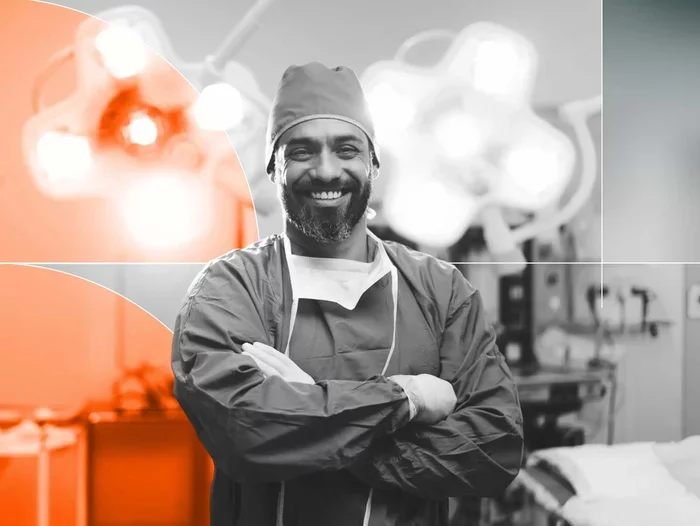 Smiling surgeon with arms crossed in an operating room, accented by orange circular graphics.