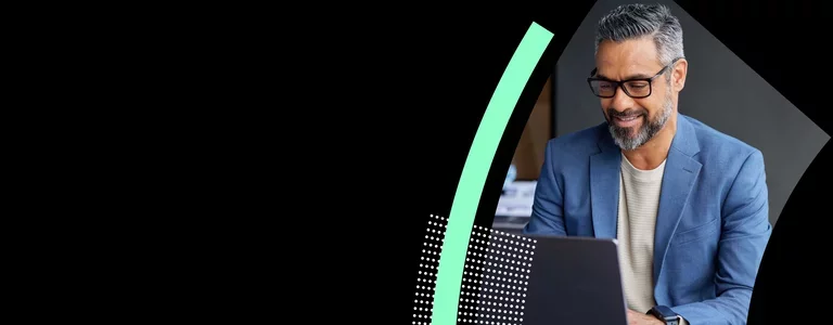 Professional working on laptop reviewing data in modern office.