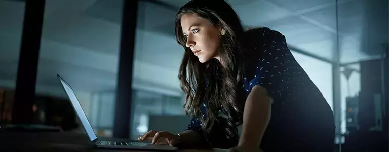 Woman Uses Laptop Protected by Digital Security Risk Solution