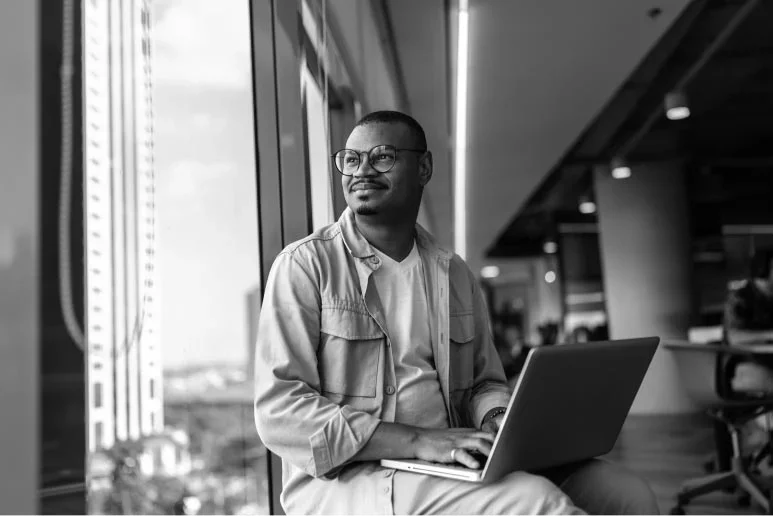 Professional working on a laptop near a window in a modern office