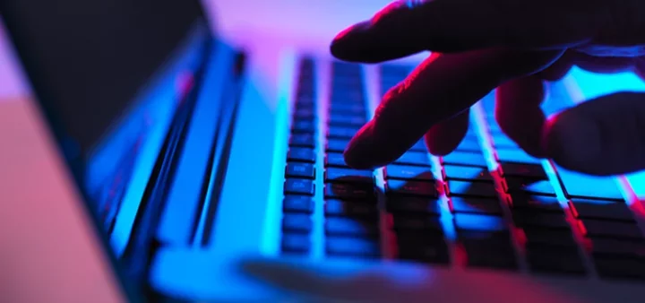 Fingers Typing on Laptop Protected by Email Security Solution