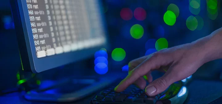 Person typing in a dark server room