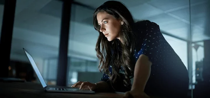 Woman Uses Laptop Protected by Digital Security Risk Solution