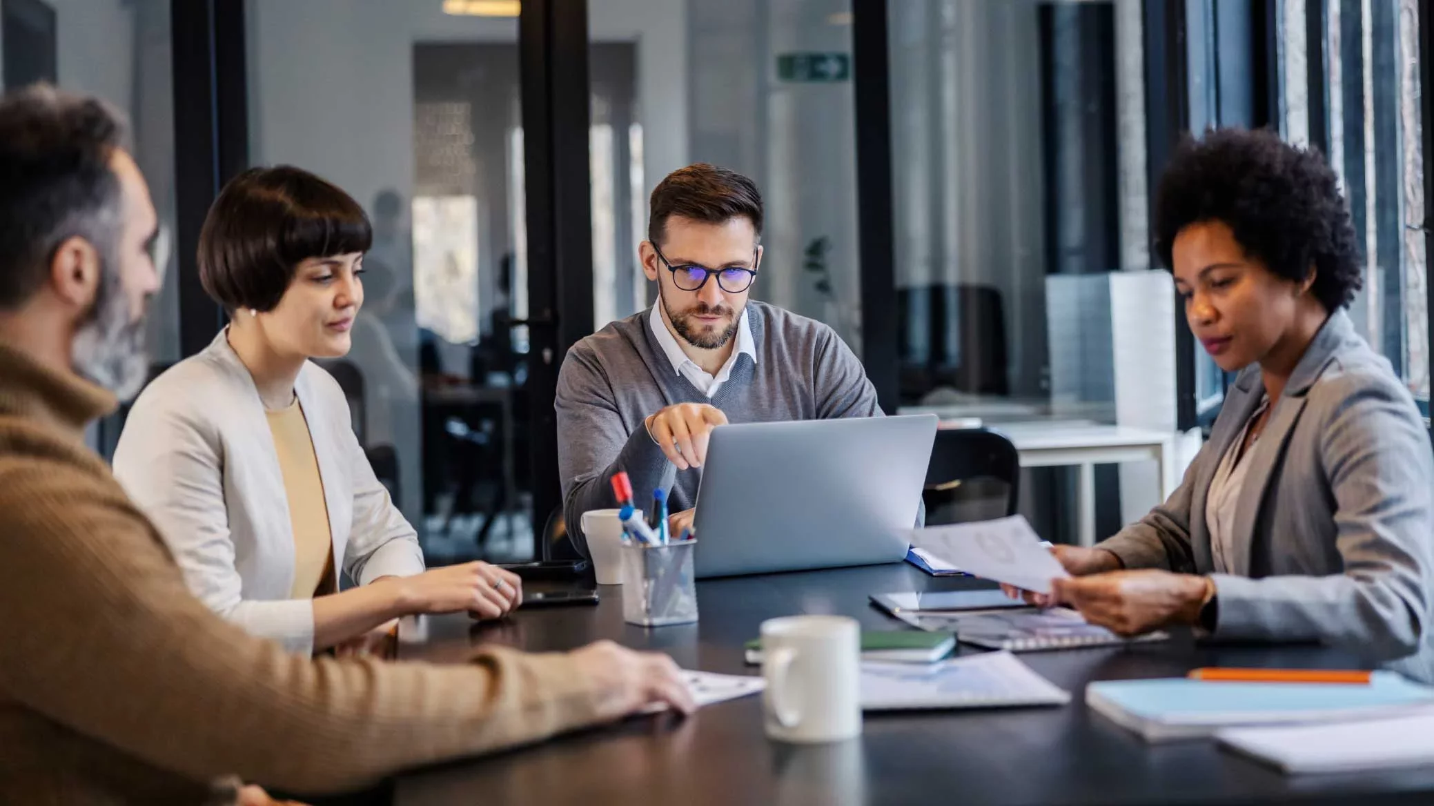 Team reviewing documents and data around conference table.
