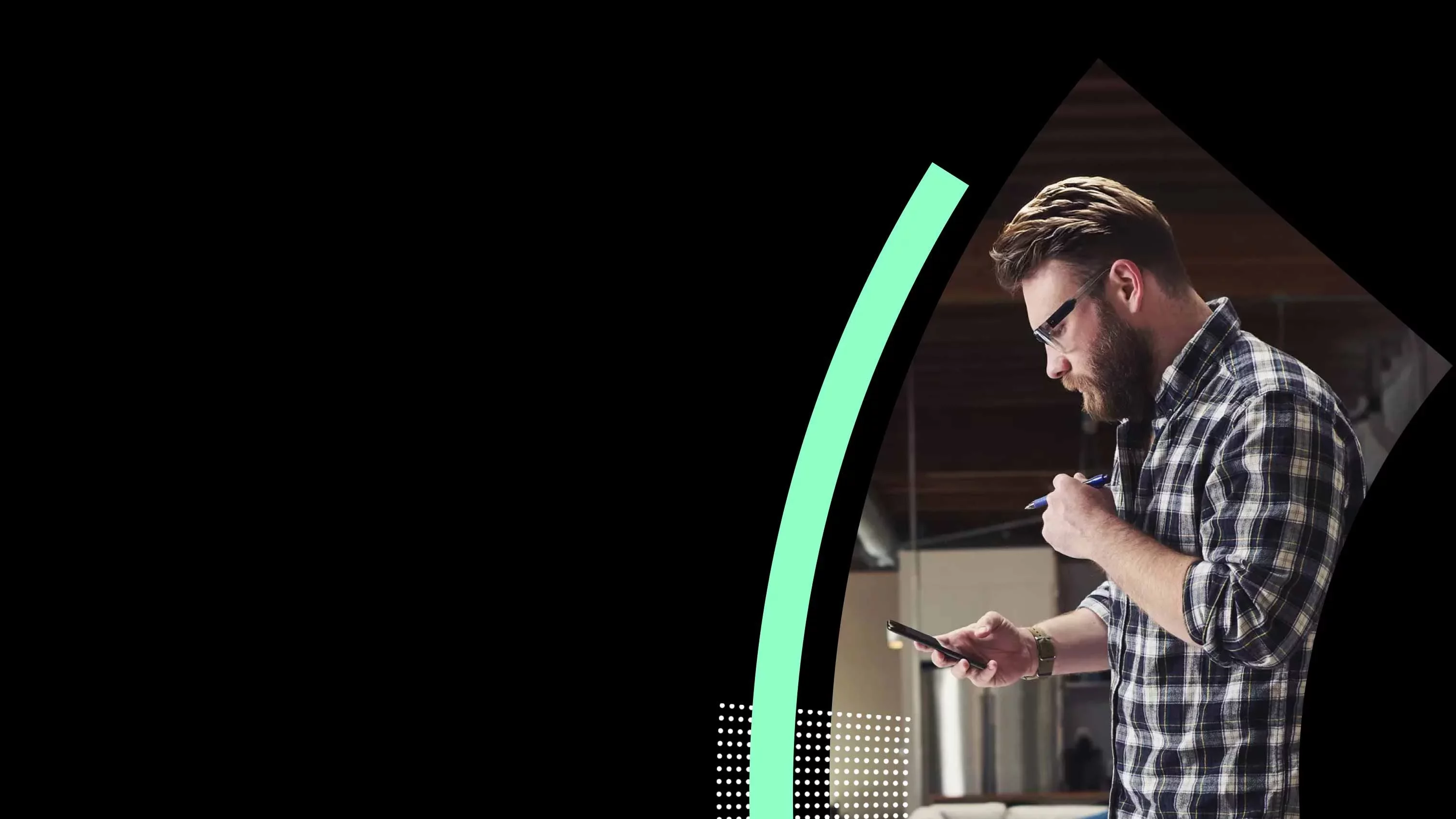 Security professional checking phone in modern workspace setting.