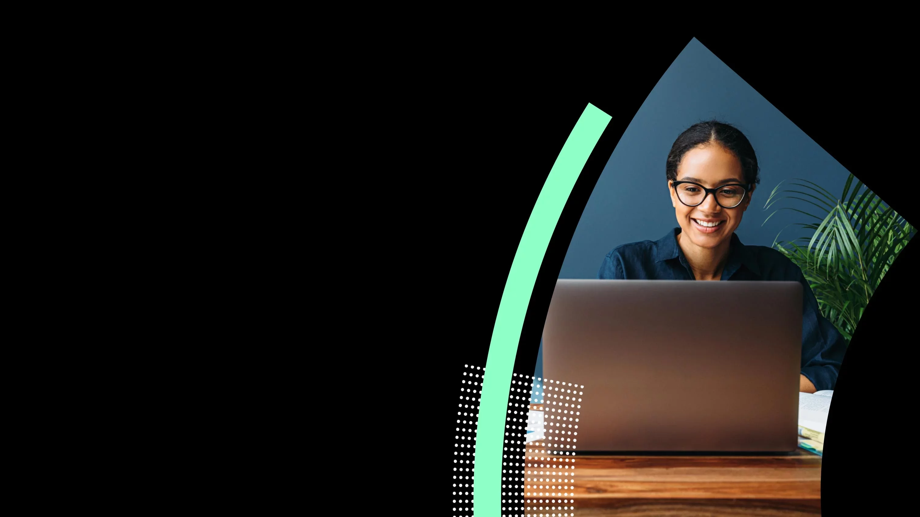 Professional smiling while working on laptop at desk in office.