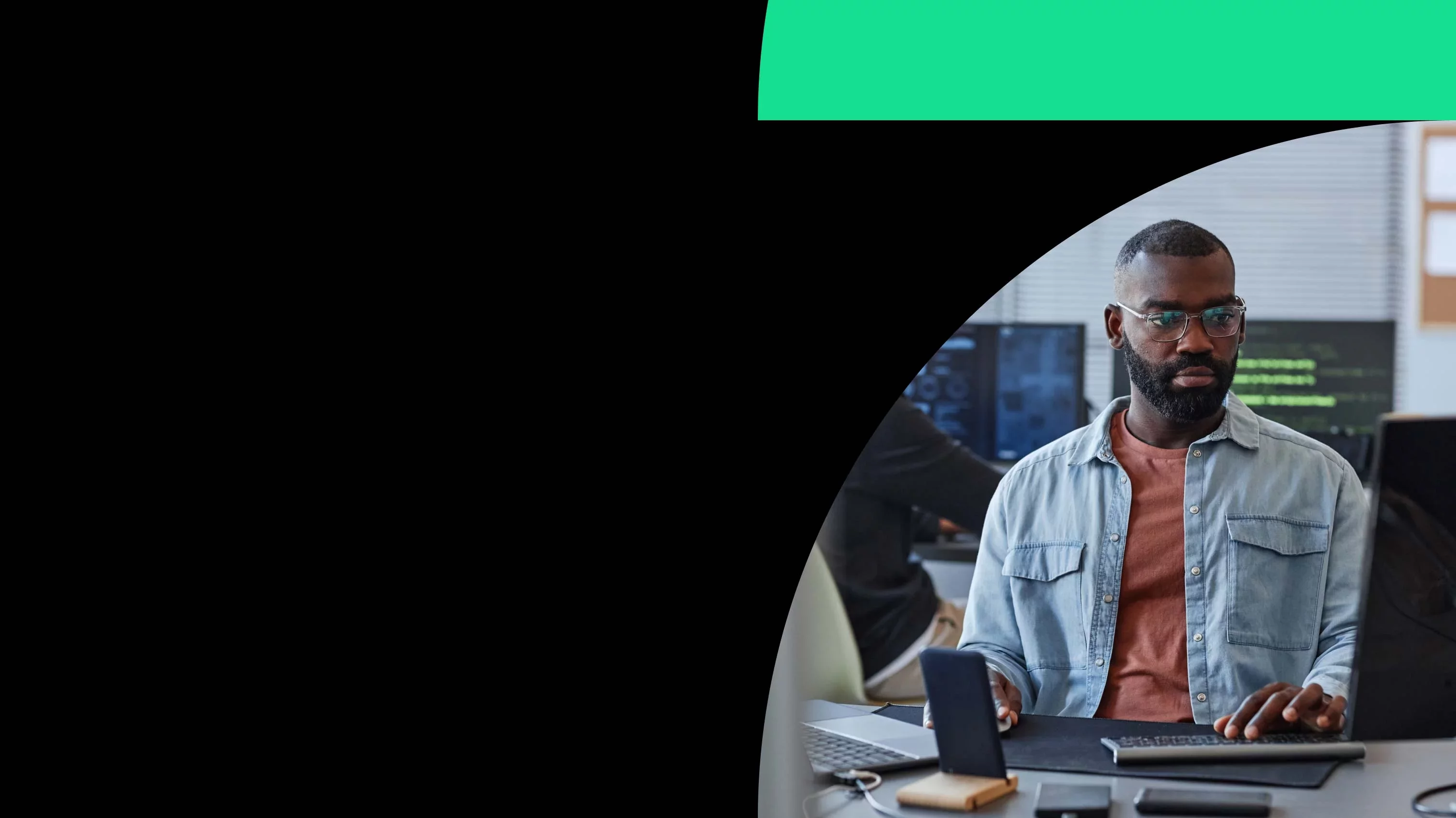 Cybersecurity analyst monitoring systems at workstation in office environment.