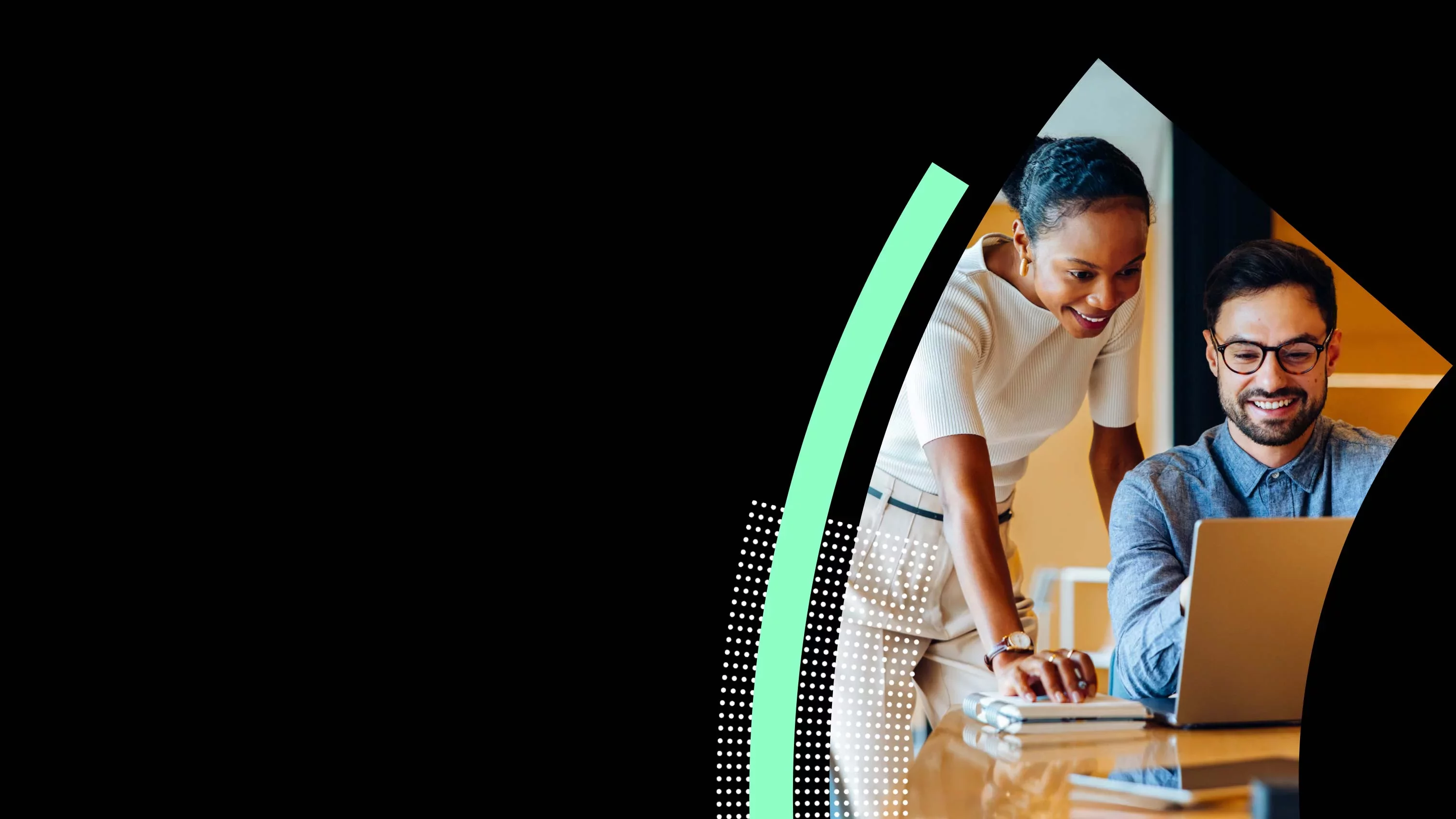 Two professionals collaborating over laptop reviewing data in modern office.