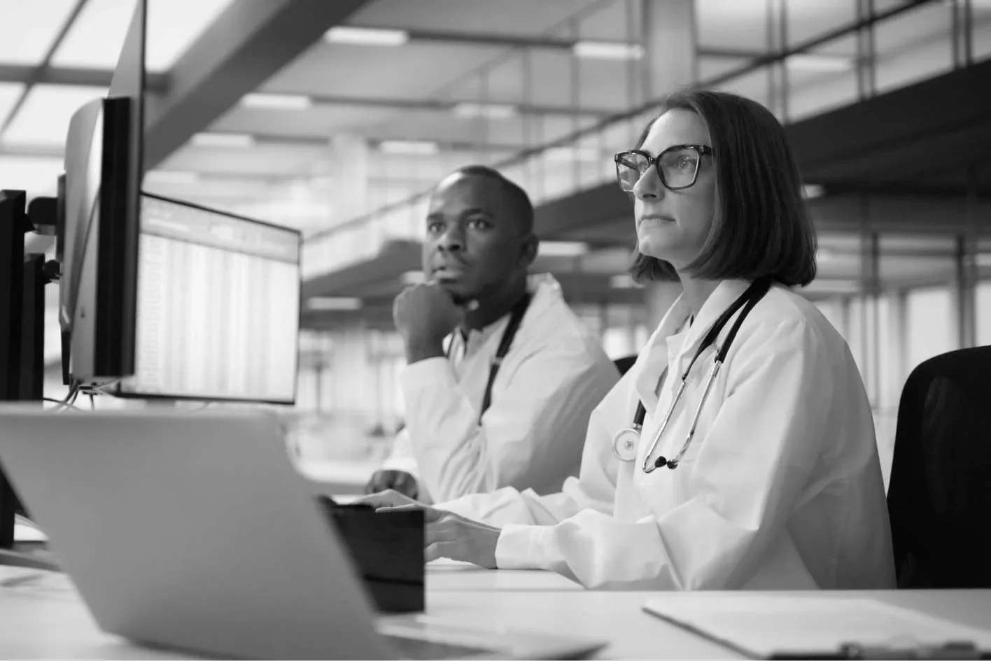 Healthcare professionals reviewing clinical data on computer screens